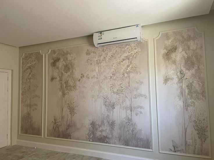 جدار داخلي مزين بورق جدران فاخر بالمدينة المنورة بتصميم أشجار طبيعية بألوان هادئة، يضفي لمسة فنية في غرفة مزودة بمكيف
