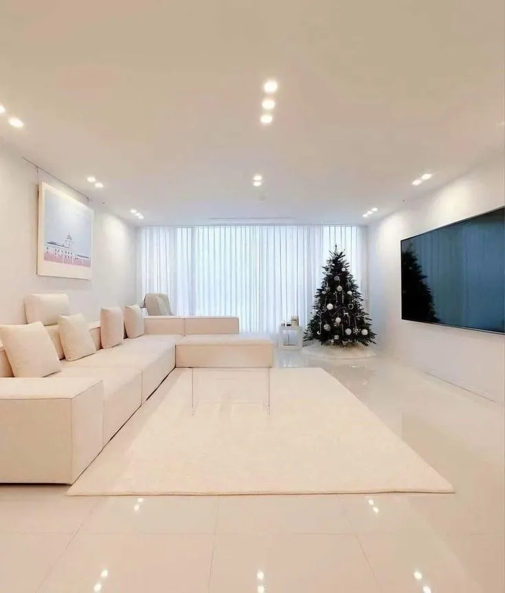 اثاث بيج وشجرة عيد ميلاد وشاشة سوداء داخل شقة تم عمل دهانات لها