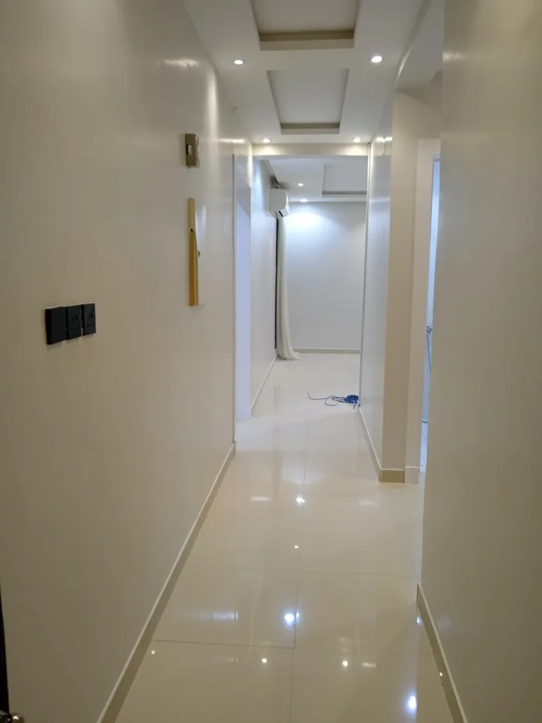 ممر داخلي بتشطيب دهانات فاخرة باللون الأبيض اللامع في أحد منازل المدينة المنورة، من تنفيذ معلم دهانات محترف يتميز بالدقة