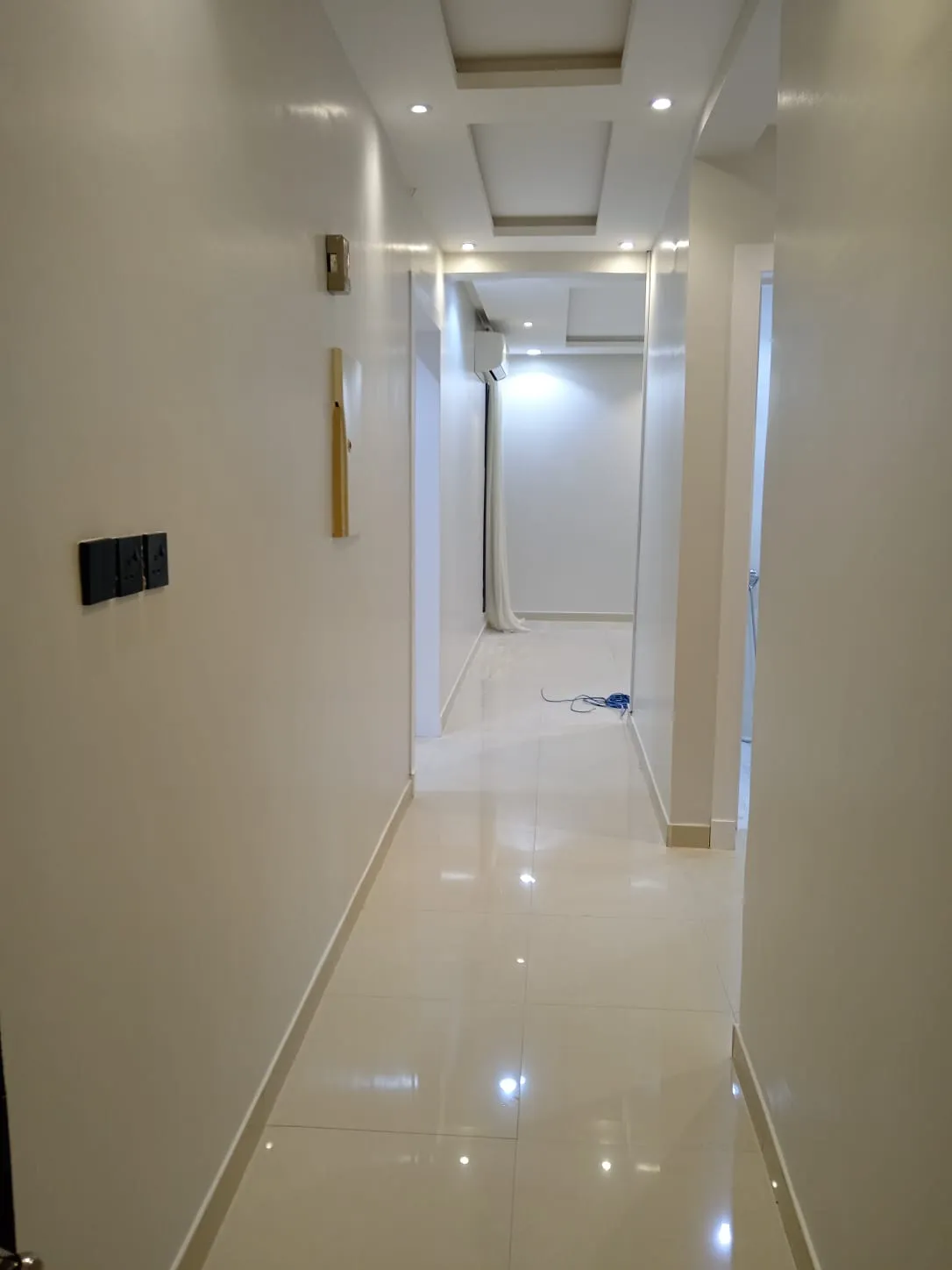 ممر داخلي بتشطيب دهانات فاخرة باللون الأبيض اللامع في أحد منازل المدينة المنورة