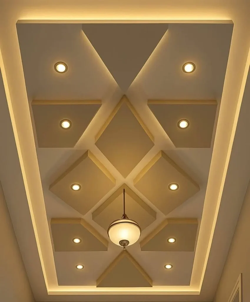 سقف جبس بورد بتصميم هندسي ثلاثي الأبعاد يعتمد على الأشكال الماسية والمربعات المتداخلة باللون البيج ومضاء بإضائة محيطية