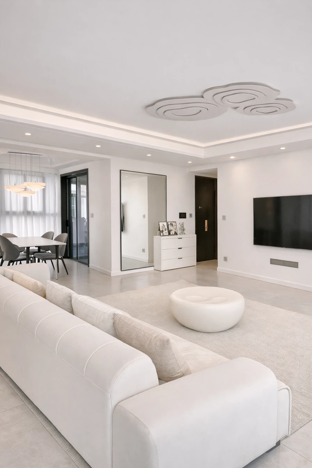 دهان صالة باللون الأبيض مع سقف جبس بورد بإضاءة مخفية وتلفزيون جداري وطاولة طعام جانبية