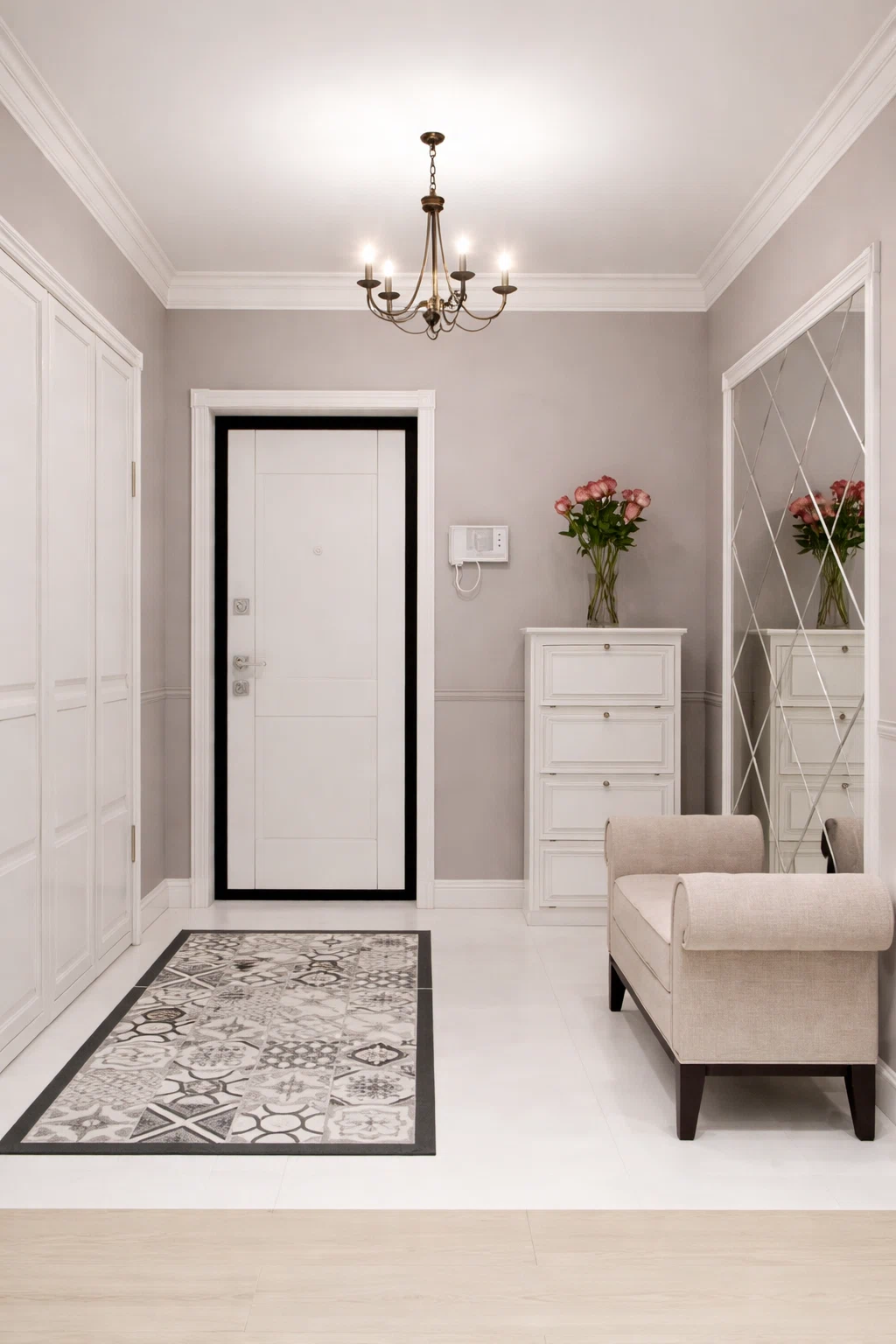 دهان مدخل منزل كلاسيكي بلون رمادي فاتح مع كرانيش سقفية وثريا أنيقة وأثاث أبيض ومرايا ديكورية